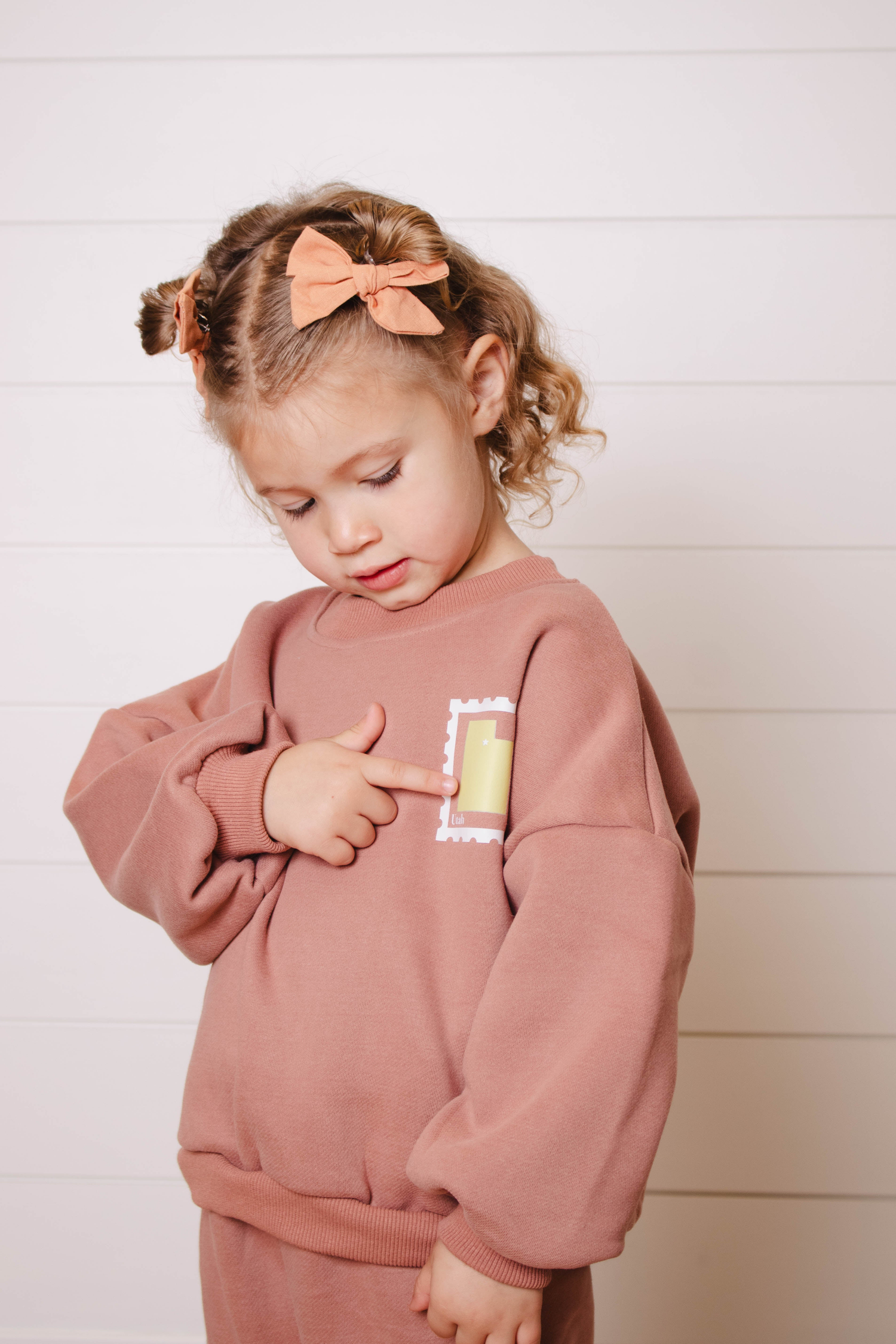 Two children in brown sweatsuits exploring